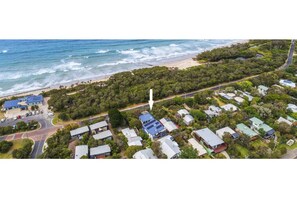 Coastal homes nestled among lush greenery and trees, overlooking the ocean.