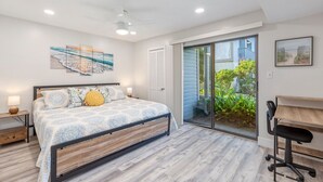 A bedroom with a bed, bedside table, and a desk with a chair.
