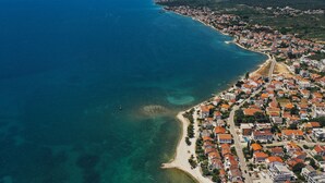 An aerial view of a coastal town with a beach, houses, and a clear blue sea. - Adria Concept boutique apartments (Zadar)