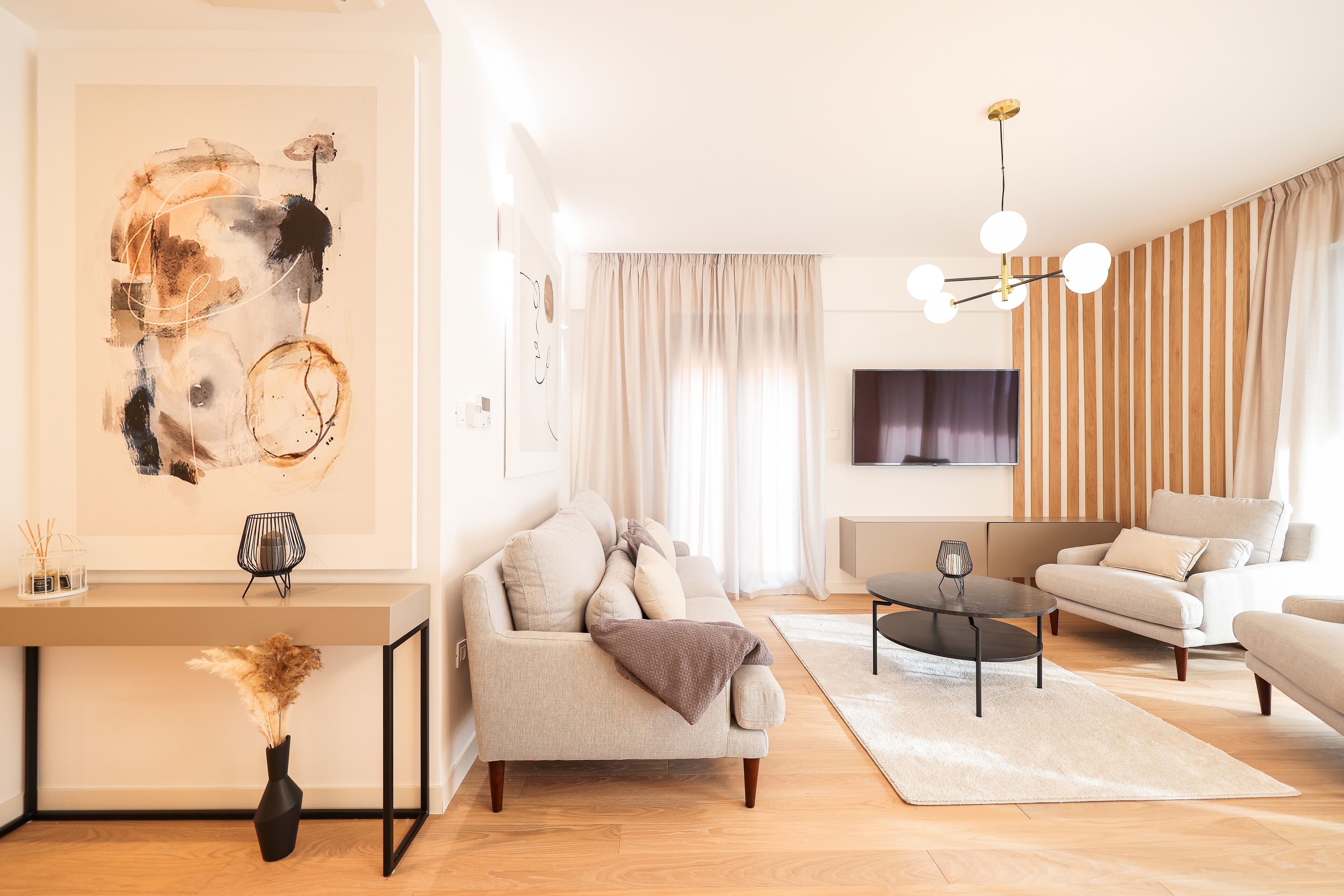 Een moderne woonkamer met een bank, salontafel en een schilderij aan de muur.