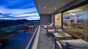 A modern balcony with glass railings, lounge chairs, and a dining area with a table and chairs. - Adria Concept boutique apartments (Zadar)