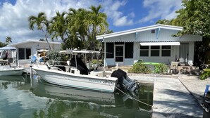 A boat docked at a marina with a house nearby.