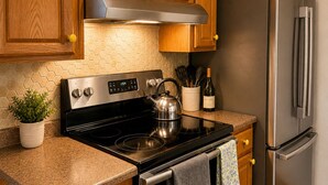 A kitchen with wooden cabinets, a stainless steel stove, and a refrigerator.