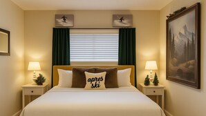 A hotel room with a large bed, two nightstands with lamps, a window with blinds, and two wall-mounted pictures.