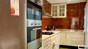 A kitchen with white cabinets, a stainless steel oven, a gas stove, and a sink. - Modern apartment close to the Camp Nou Stadium (BARCELONA)