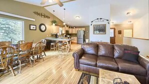 A spacious living area with a brown leather sofa, wooden dining table, and chairs. A ceiling fan and recessed lighting are visible. - Black Hills SD Deadwood, Privacy, Comfort & Convenience with Breathtaking Views (Lead)