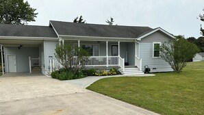 A two-story house with a front porch, a covered garage, and a well-maintained lawn.