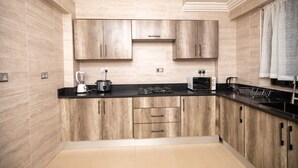 Una cocina moderna con armarios de madera, encimera negra y estufa empotrada.