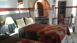A hotel room with two beds, a nightstand, a lamp, a mirror, and a small table with a chair. - HOTEL TERRANOVA TAMPICO (Tampico)