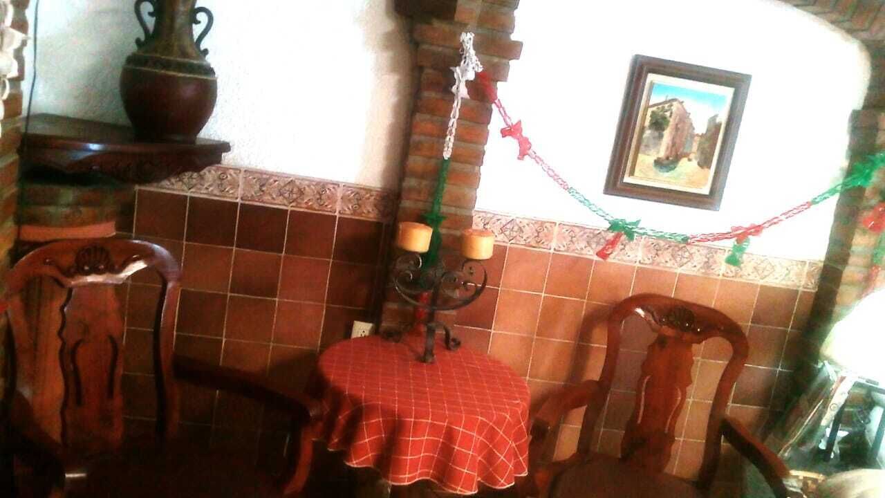 A dining area with a table set for two, a candelabra, and a wall-mounted picture.