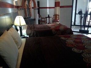 A hotel room with two beds, a nightstand, a lamp, a chair, and a window with a view of the outside. - HOTEL TERRANOVA TAMPICO (Tampico)