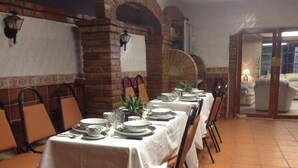 A dining area with tables set for a meal, brick walls, and a tiled floor. - HOTEL TERRANOVA TAMPICO (Tampico)