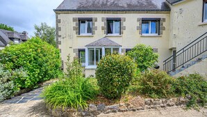 A two-story house with a stone facade, a central entrance with a window, and a staircase on the right. - Tildren - Guern - Gîte (GUERN)
