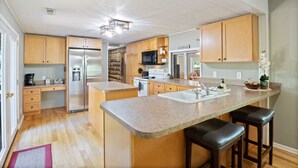 Una cucina moderna con mobili in legno, elettrodomestici in acciaio inossidabile e un piano di lavoro in granito.