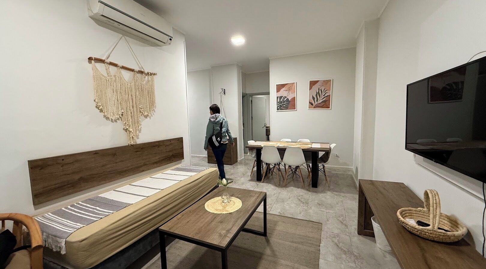 Una sala de estar moderna con sofá, mesa de comedor y televisor.