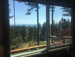 Enjoy a serene forest view from your balcony, overlooking a tranquil landscape of coniferous and deciduous trees.
