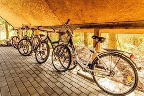 Ein überdachter Fahrradparkbereich mit unter einem hölzernen Vordach abgestellten Fahrrädern.