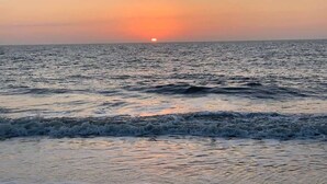 A sunset over the ocean with waves approaching the shore. - Ocean Villa C147 - Steps from Beach and Pool (Hilton Head Island)