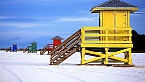 A series of wooden lifeguard towers in various colors, with a clear sky and snow-covered ground. - Condo# 219 Siesta key Paradise unit 219 (Sarasota)
