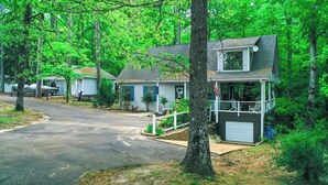 A row of single-story houses with attached garages, surrounded by dense green trees. - Bright Aqua Yacht Harbor Pickwick Lake Lakeview Home Boat Garage Sleeps 10+ (Iuka)