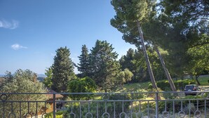 A fenced garden with trees and a building in the background. - S267 - Sirolo , portion of a single villa surrounded by the greenery of Conero (Sirolo)