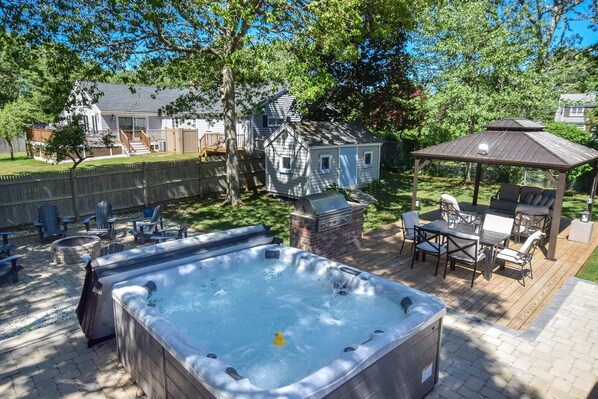 Ein Garten mit Whirlpool, Sitzgelegenheiten im Freien und Grillplatz.