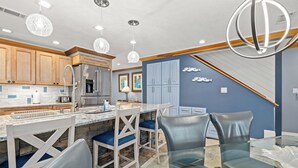 A modern kitchen with wooden cabinets, a stainless steel refrigerator, and a marble island with bar seating. - Beautiful Mainsail Townhome Sleeps 8 .   3 bedrooms3 bathrooms Gated Community  (Miramar Beach)
