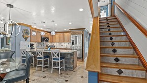 A modern kitchen with a central island, wooden cabinets, and a stainless steel refrigerator. - Beautiful Mainsail Townhome Sleeps 8 .   3 bedrooms3 bathrooms Gated Community  (Miramar Beach)