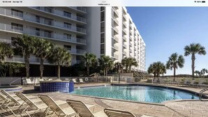 A hotel pool area with lounge chairs and a large building in the background. - Beautiful Mainsail Townhome Sleeps 8 .   3 bedrooms3 bathrooms Gated Community  (Miramar Beach)