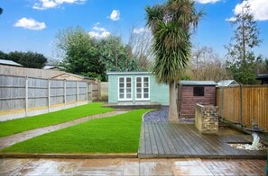 Enjoy the serene backyard with a well-maintained lawn, deck, and shed.