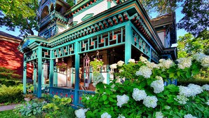 A traditional building with a porch and hanging flower baskets.