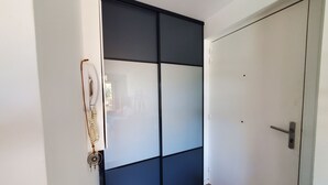 Ein Zimmer mit einer Schiebetür, einer weißen Wand und einem Holzboden.