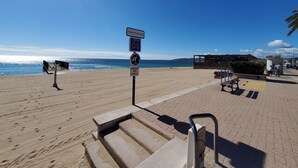 Ein Strand mit einem öffentlichen Badebereich, einem Rettungsturm und einer Aussichtsplattform.