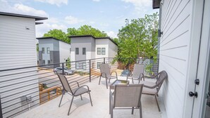 A patio area with outdoor furniture and a view of neighboring buildings. - Experience Modern Luxury! 3br/2.5ba Home Near DT (San Antonio)