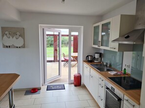 A modern kitchen with a sliding glass door leading to a patio area. - Seesternchen Fewo Nr. 1 (St. Peter-Ording)