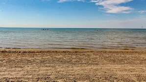 A sandy beach with calm water and a clear sky. - beachfront (Wasaga Beach)