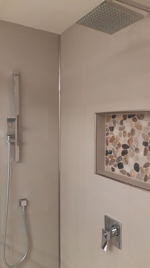Een bad/douchecombinatie, een haardroger, handdoeken, zeep