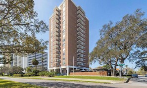 A high-rise residential building with multiple balconies, a flat roof, and a well-maintained lawn. - 2 Bd/2 Ba Bayshore Blvd Condo - 10th Floor Bay & City views - Newly Renovated (Tampa)