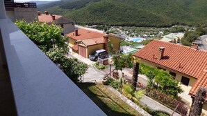 Un quartier résidentiel avec des maisons, une piscine et une vue sur des collines verdoyantes.