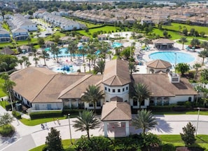 A large resort with multiple buildings, a central pool area, and surrounding greenery.