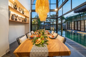 Enjoy meals in this dining area with a large table, patterned table runner, and tropical centerpiece.