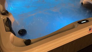 A hot tub with a blue light feature, a control panel, and a label indicating it is made in the USA.