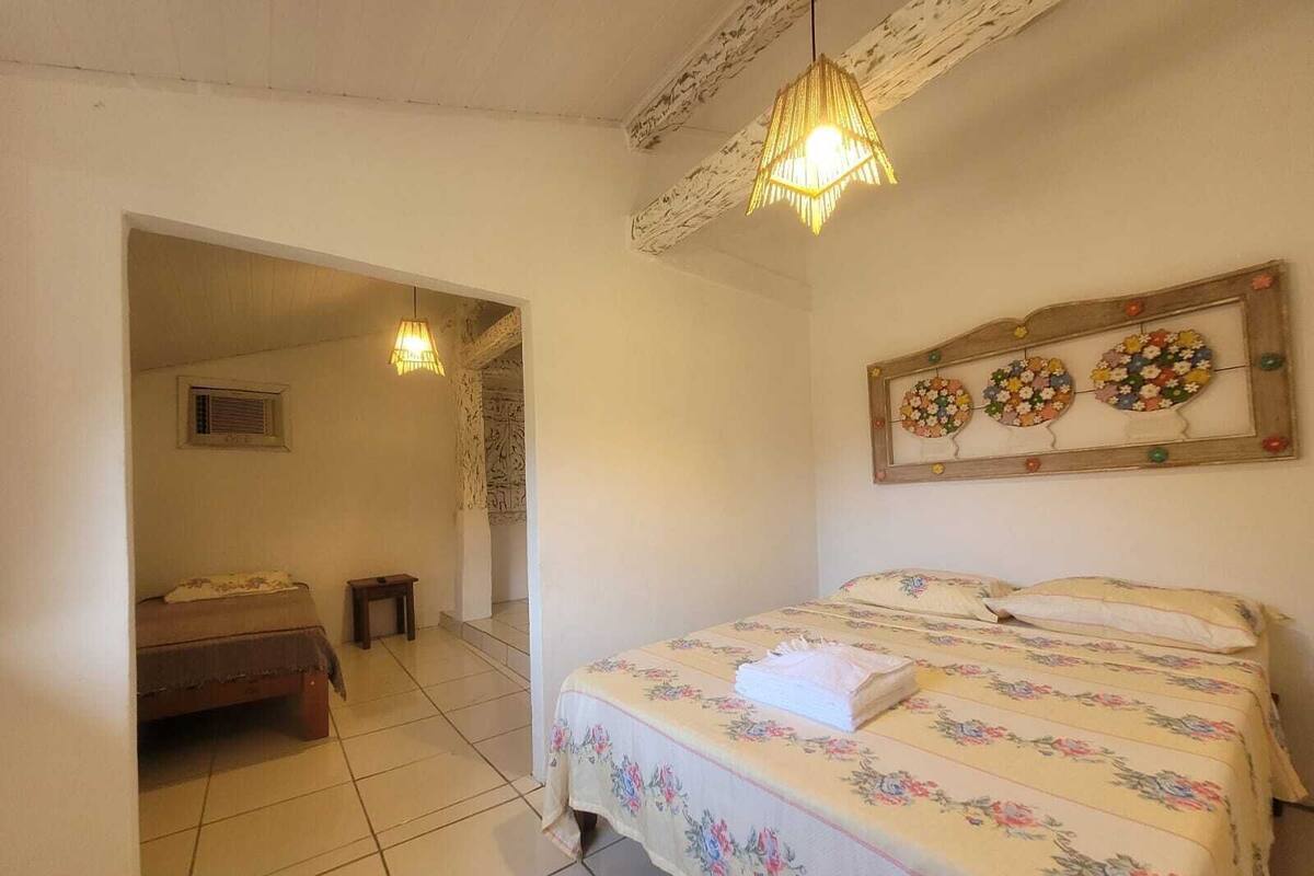 Una camera da letto con un letto, un tavolino, uno specchio a muro e un lampadario.