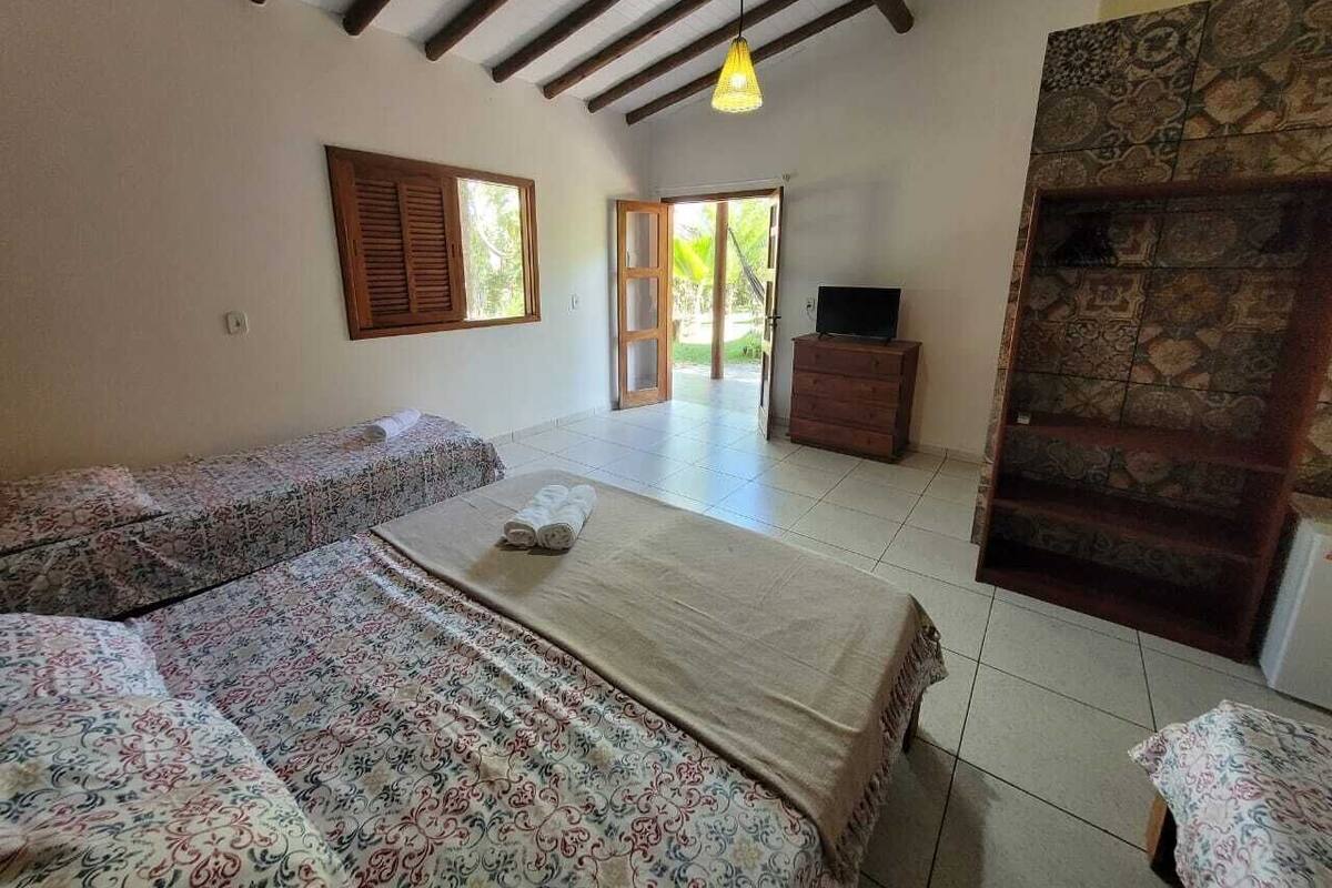 Una stanza con un letto, un divano, una televisione e un muro in pietra.