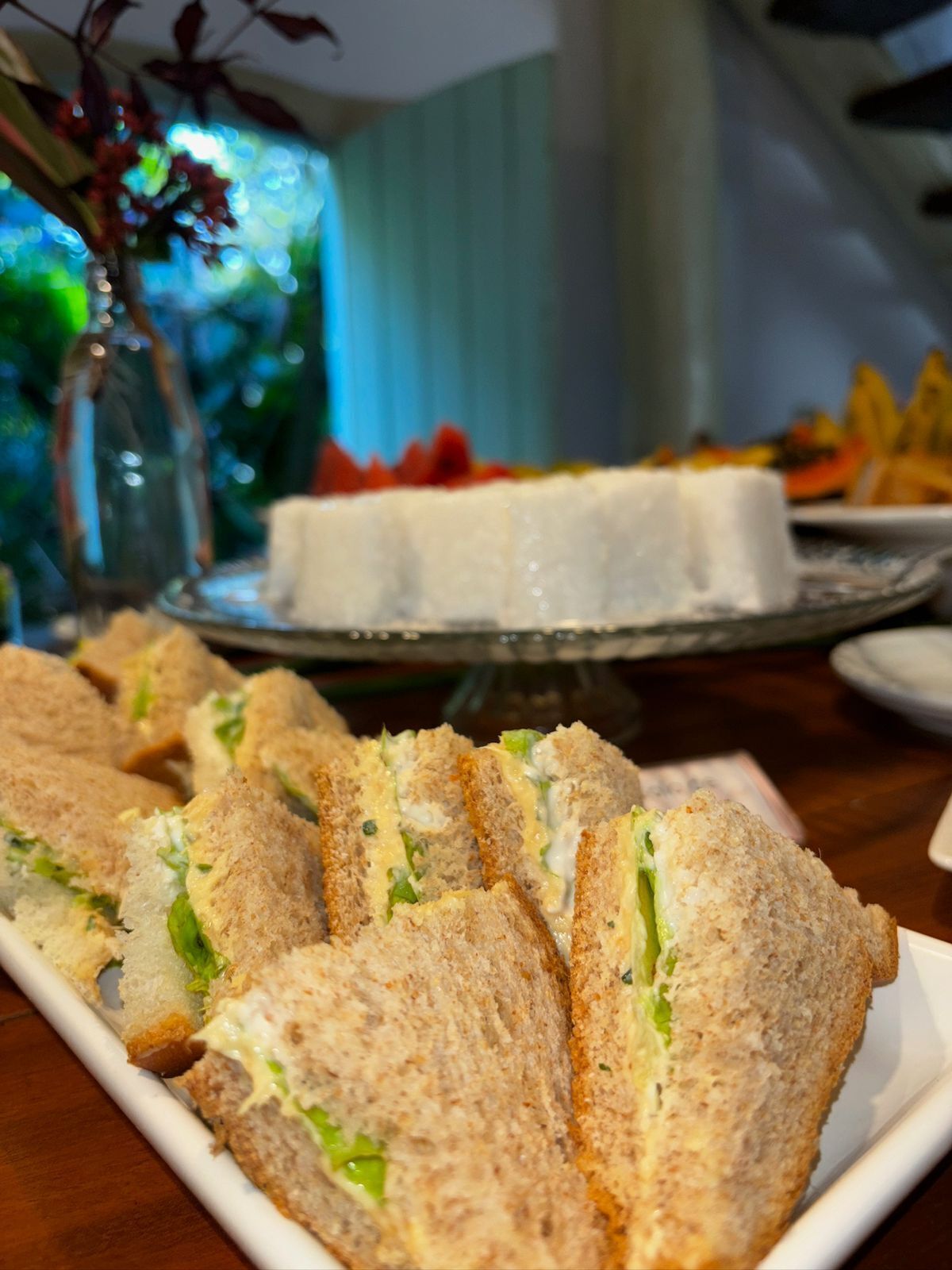 A table with sandwiches and a cake.