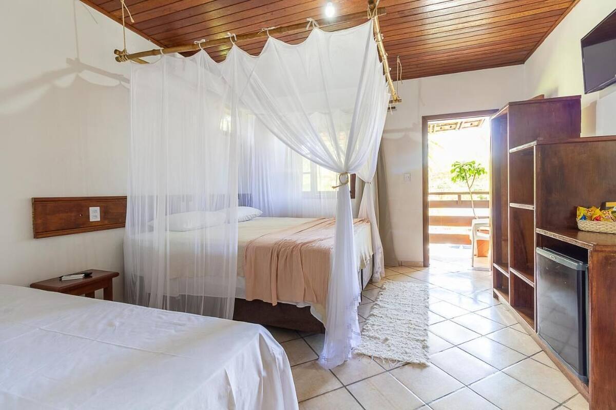 Una camera da letto con un letto a baldacchino, un comodino e un armadio.