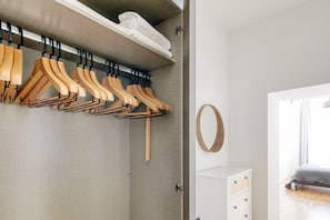 Guests can store their belongings on the wardrobe's shelf and hang their clothes on the available hangers.