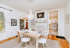 Enjoy meals in this elegant dining area with a chandelier, fireplace, and views into the adjacent kitchen.