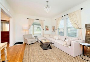 Relax in this inviting living room with a large sofa, coffee table, and armchair.