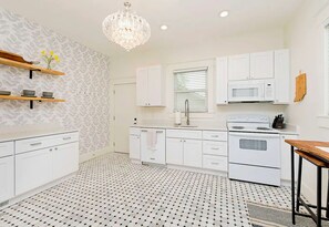 Enjoy cooking in this well-equipped kitchen with a central island, oven, and patterned backsplash.